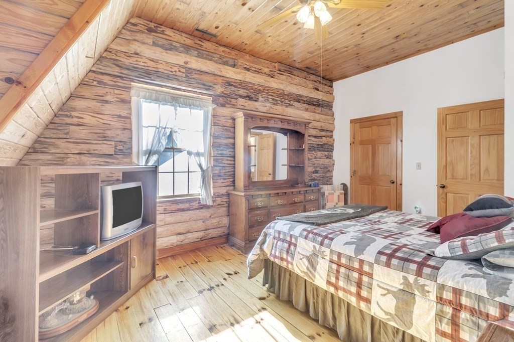 160 Laurel Hill Road Westhampton, MA 01027 - Photo 36 of 42 a bedroom with a bed wooden floor and flat screen tv