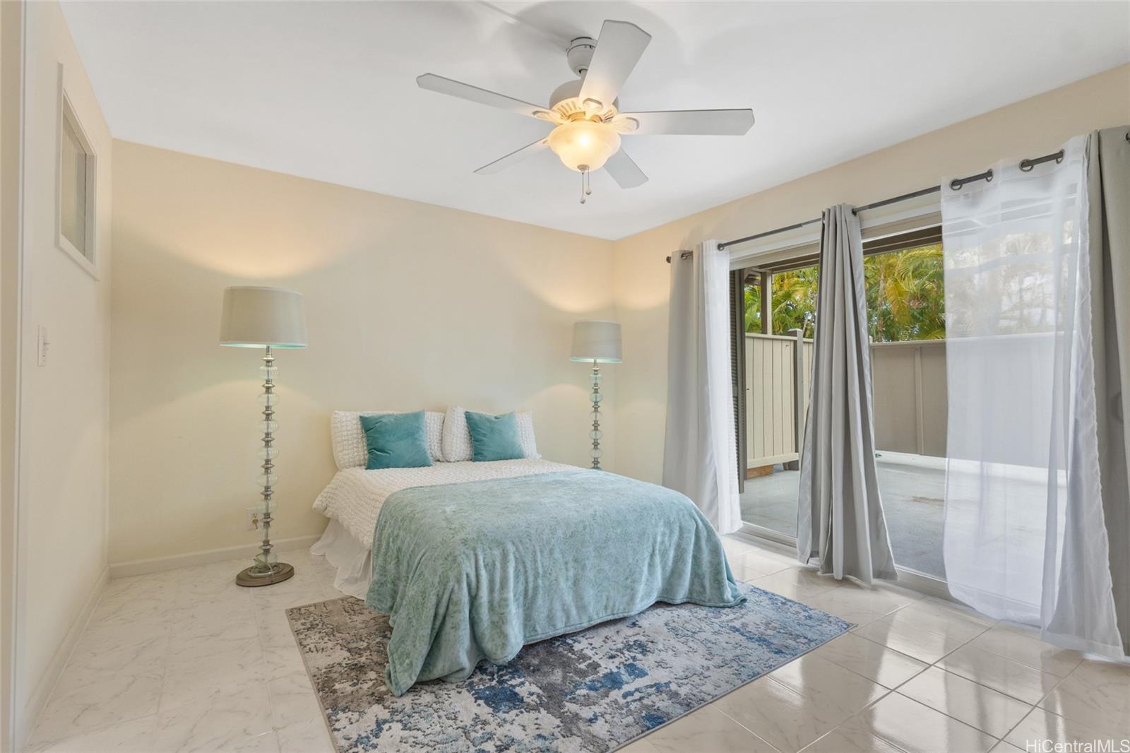 45-995 Wailele Road, Unit 29 Kaneohe, HI 96744 - Photo 13 of 25 a spacious bedroom with a bed and a chandelier