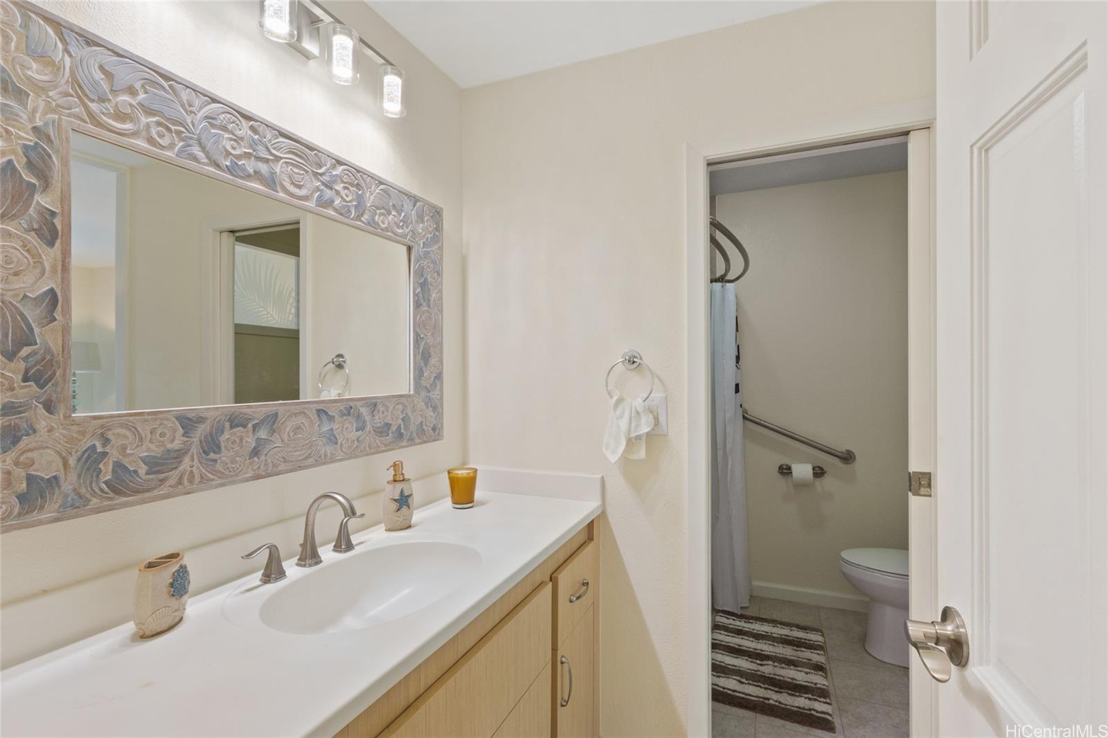 45-995 Wailele Road, Unit 29 Kaneohe, HI 96744 - Photo 16 of 25 a bathroom with a sink and mirror with toilet