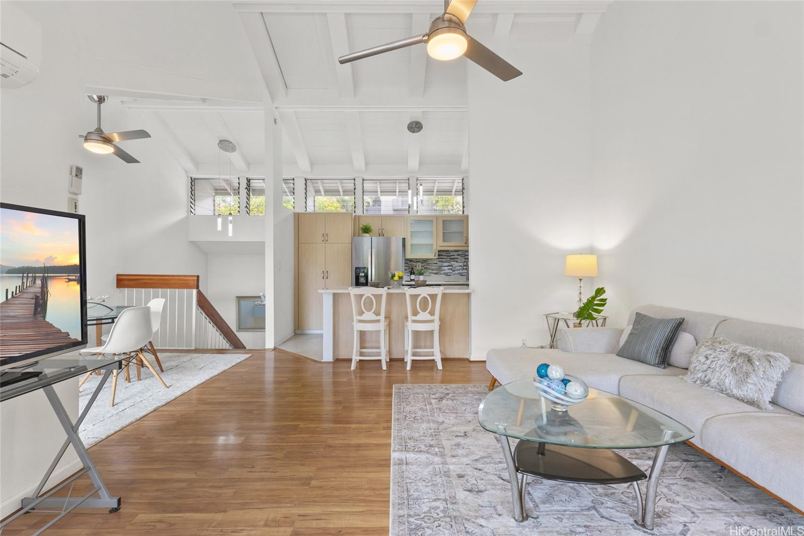 45-995 Wailele Road, Unit 29 Kaneohe, HI 96744 - Photo 8 of 25 a living room with furniture and a dining table with floor to ceiling window