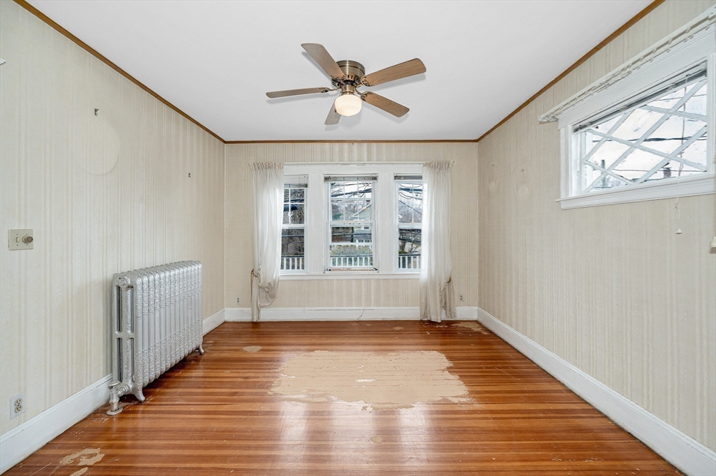 481 Lagrange Street Boston, MA 02132 - Photo 7 of 32 a view of an empty room with a window and wooden floor