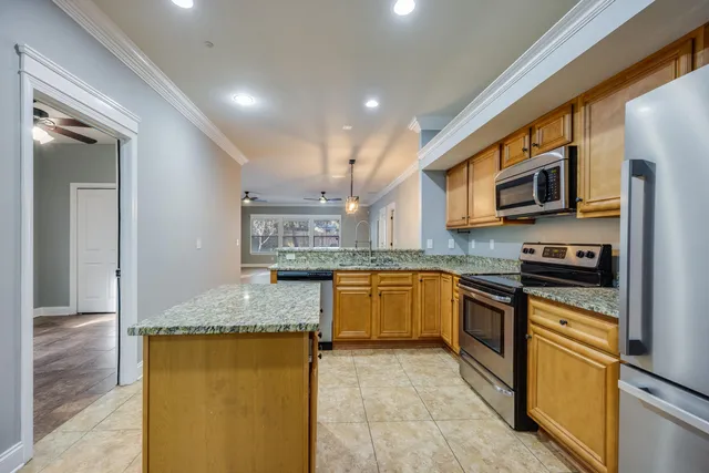 a kitchen with stainless steel appliances granite countertop a stove a sink and a microwave