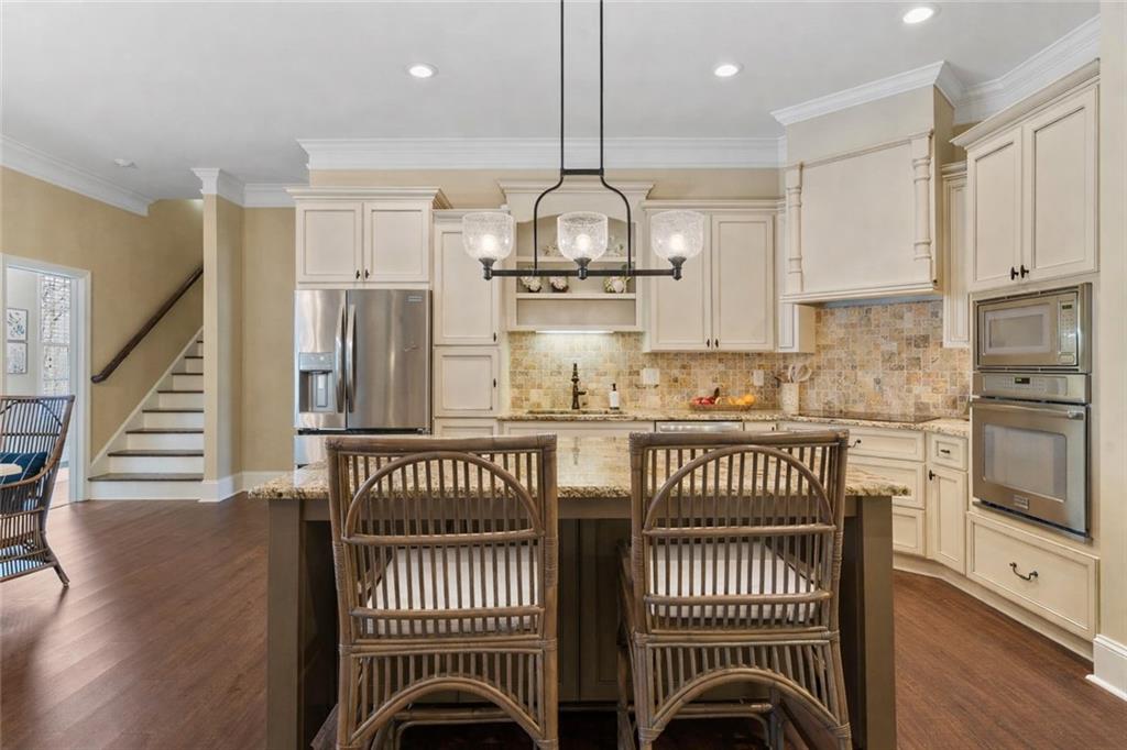 2995 Gum Creek Road Oxford, GA 30054 - Photo 7 of 51 a kitchen with stainless steel appliances granite countertop a stove top oven a refrigerator and white cabinets with wooden floor