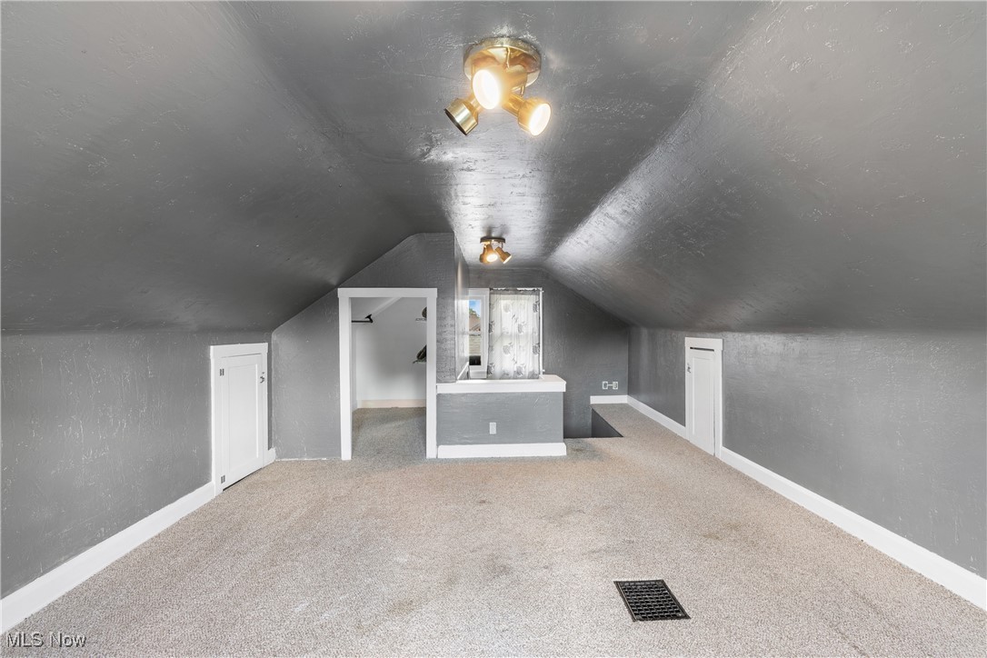 302 Poplar Avenue Northwest Canton, OH 44708 - Photo 26 of 34 Additional living space featuring vaulted ceiling and carpet floors