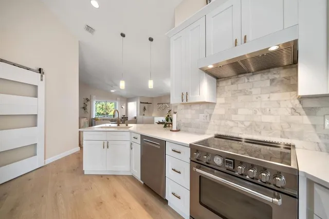 a view of a patio with a table and chairs under an umbrella with a barbeque