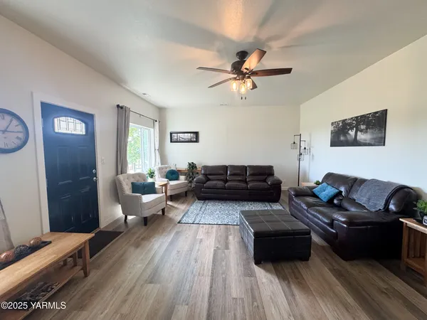 a living room with furniture and a wooden floor