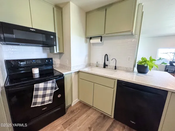 a kitchen with granite countertop a stove sink and cabinets