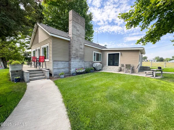 a front view of house with yard and outdoor seating