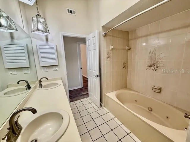 a bathroom with a sink tub and a mirror