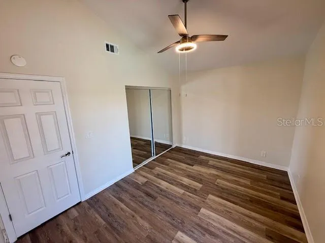 a view of empty room with wooden floor