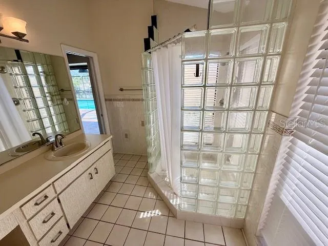 a bathroom with a double vanity sink a toilet and a shower