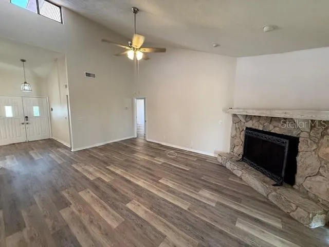 a view of empty room with wooden floor and fireplace