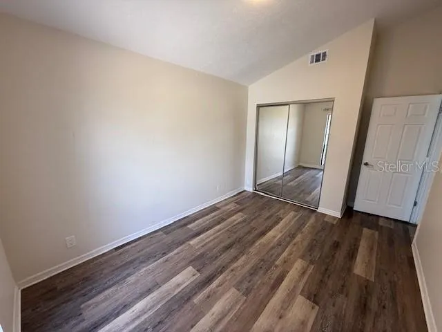 a view of empty room with wooden floor