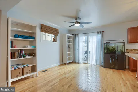 a view of empty room with wooden floor and fan