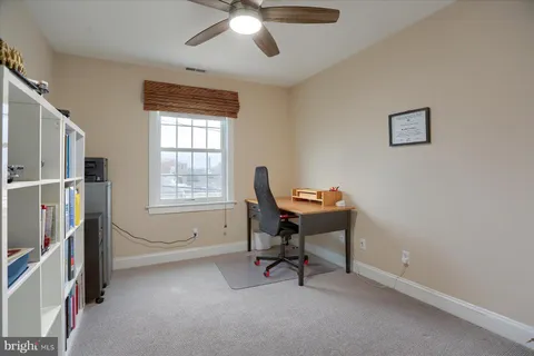 a view of a workspace with furniture and a window
