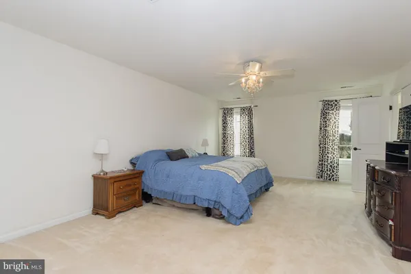 a bedroom with a bed and a flat tv screen on dresser