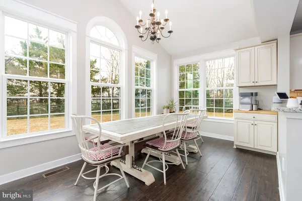 a dining room with wooden floors and white walls