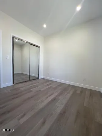 an empty room with wooden floor and mirror