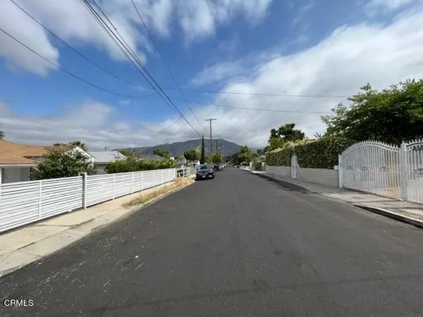 a view of a street with a car parked on the road