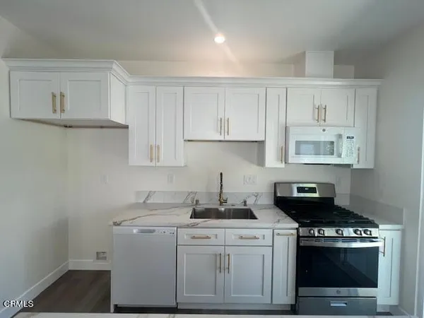a kitchen with cabinets appliances a sink and a counter top space