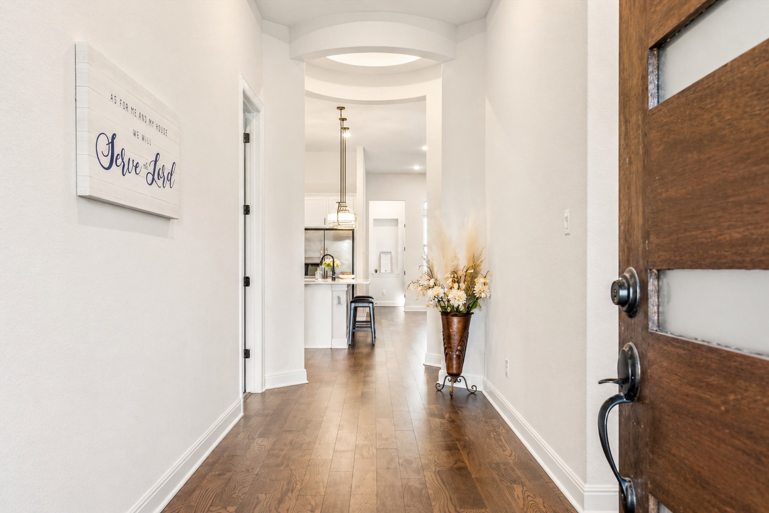 209 Rainier Drive Kyle, TX 78640 - Photo 4 of 24 Entrance hall featuring a rich wood-finish floor, a modern wood-panel entry door with frosted glass inserts, and crisp white walls