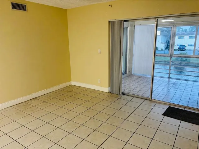 a view of a kitchen with wooden floor and a refrigerator