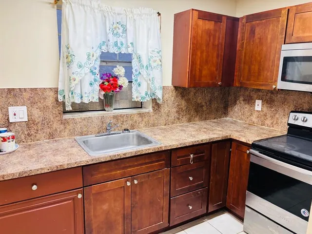 a kitchen with granite countertop a refrigerator and a sink