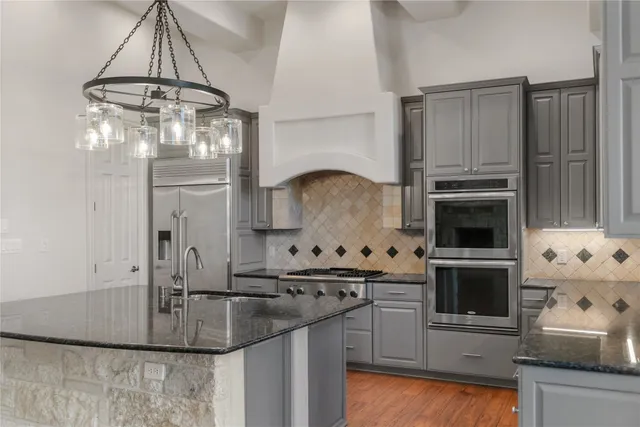 a kitchen with kitchen island a stove and a sink