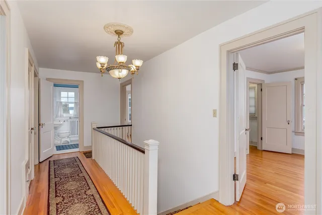 a view of a hallway with wooden floor and staircase
