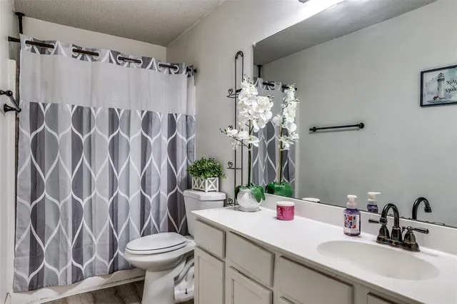 a bathroom with a sink and mirror with toilet