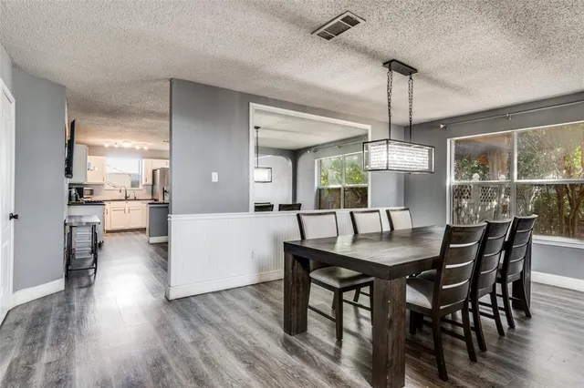 a dining room with furniture a chandelier and wooden floor