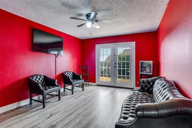 a living room with furniture a flat screen tv and a floor to ceiling window