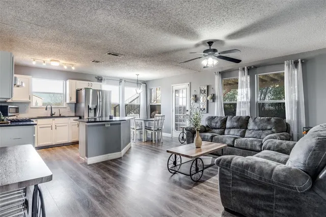 a living room with furniture kitchen and a chandelier