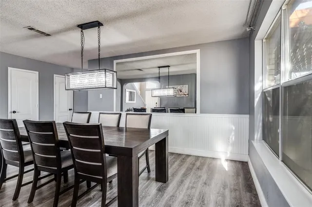 a dining table with chairs and kitchen view