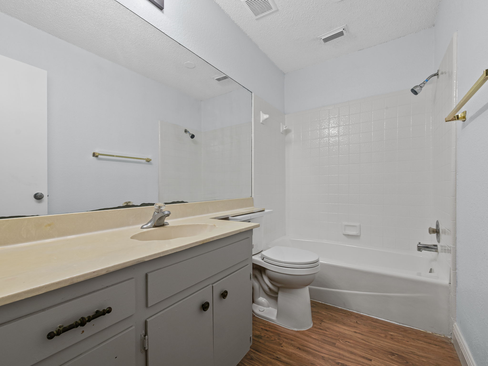 1816 Rawhide Loop, Unit 1822 Round Rock, TX 78681 - Photo 12 of 17 Full bath with wood finished floors, vanity, shower / tub combination, and a textured ceiling