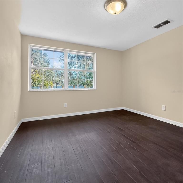 17220 Estes Road Lutz, FL 33548 - Photo 11 of 25 a view of an empty room with wooden floor and a window