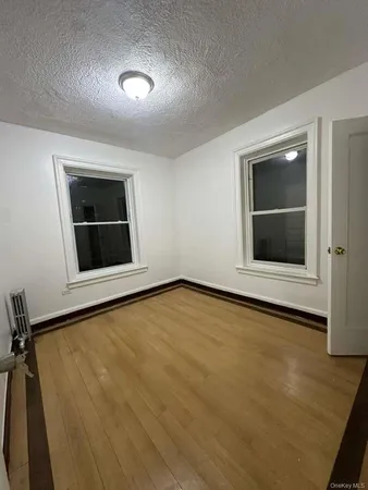a view of an empty room with a window and fireplace