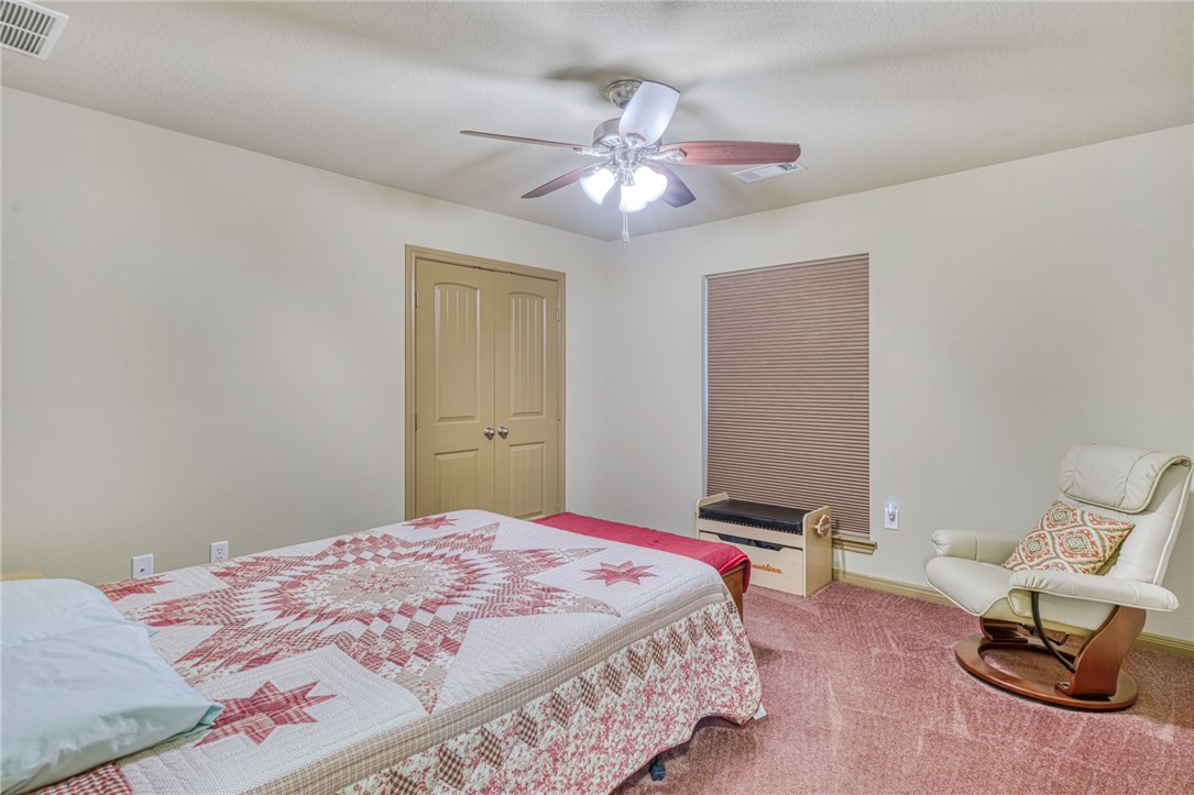 9945 Oxford Cemetery Road Madisonville, TX 77864 - Photo 22 of 42 Bedroom with ceiling fan, a closet, and carpet flooring
