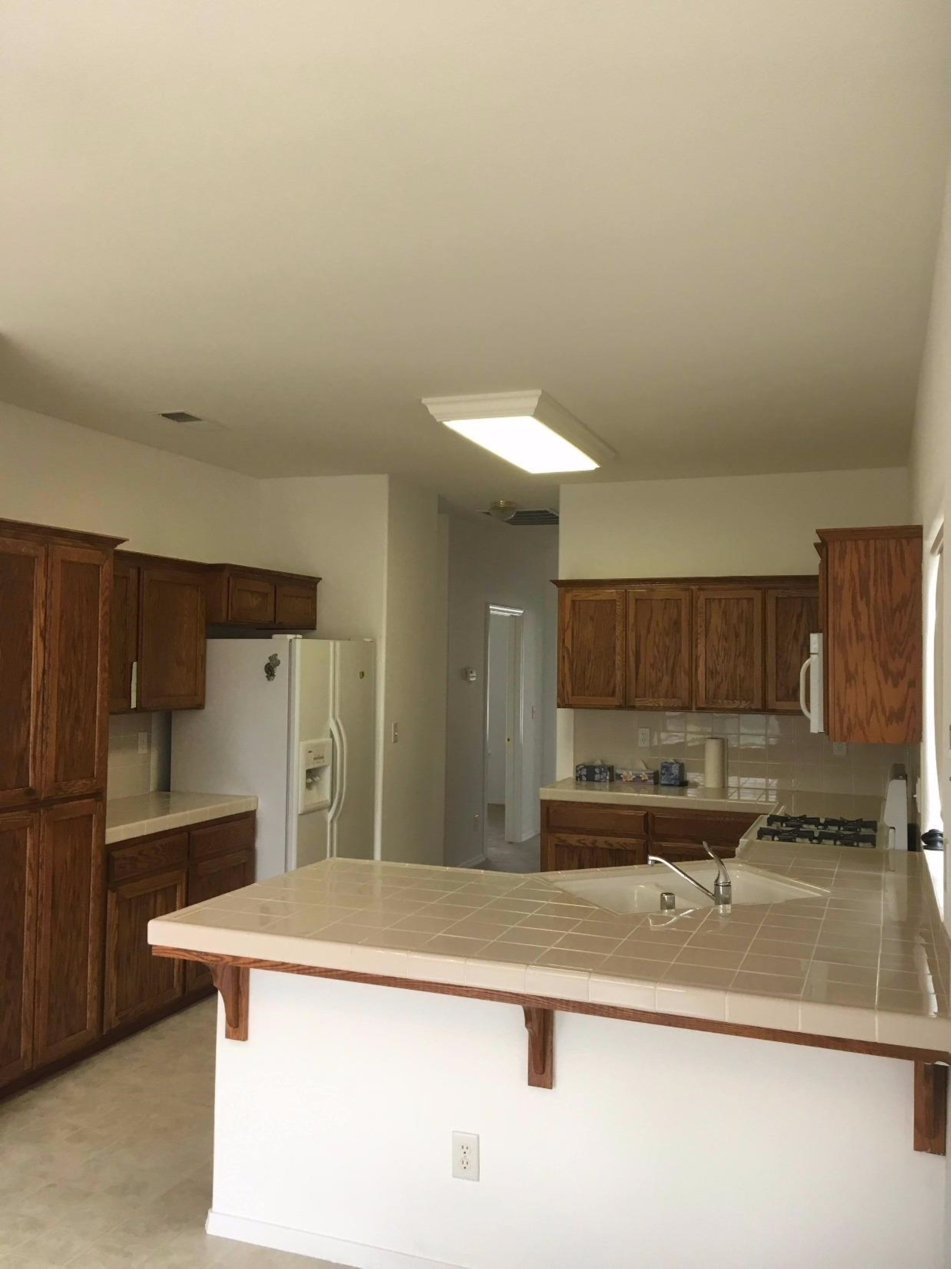 979 Maple Avenue Fowler, CA 93625 - Photo 8 of 10 a kitchen with kitchen island a sink refrigerator and cabinets