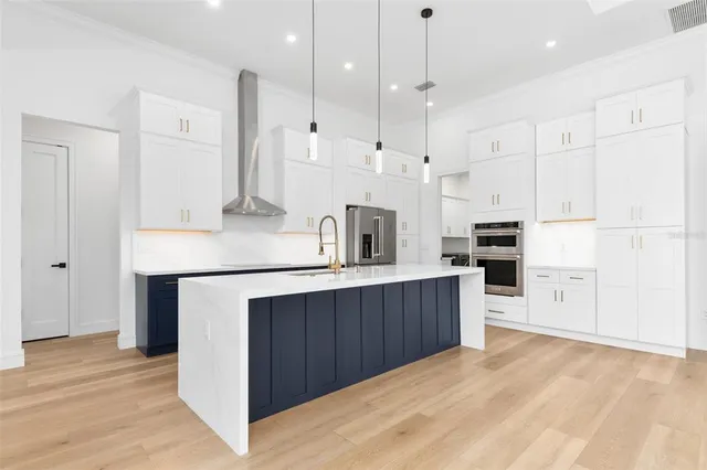 a kitchen with stainless steel appliances sink refrigerator and cabinets