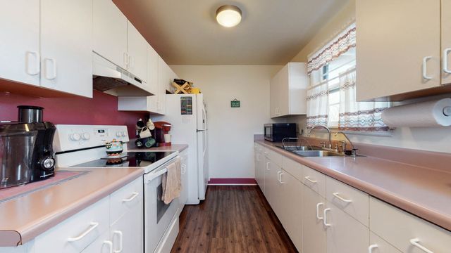 a kitchen with stainless steel appliances a sink stove and cabinets