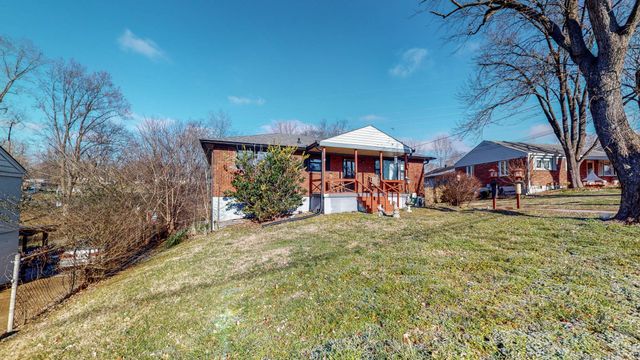 a view of a yard with a table and chairs under an umbrella
