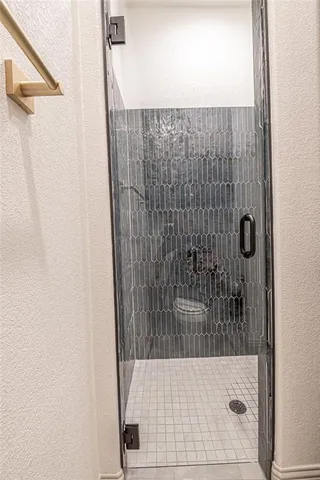 a room that has a glass door and a chandelier fan