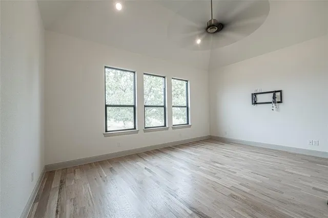 an empty room and a bathroom with a ceiling fan