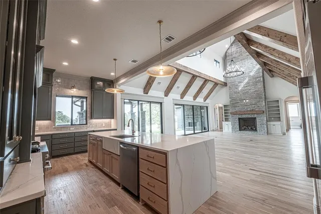 a kitchen with kitchen island granite countertop a sink and refrigerator