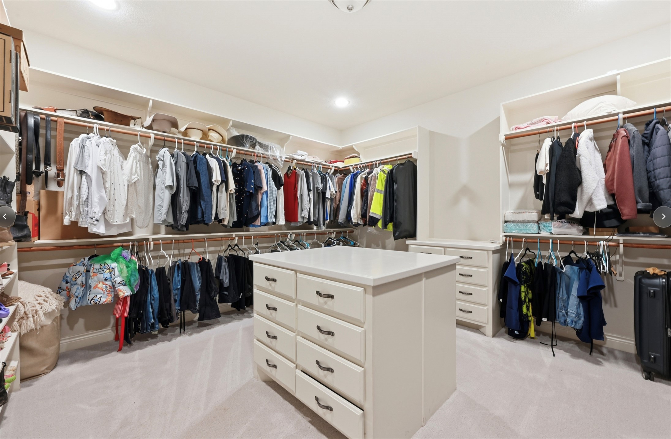 387 Corral Road Smithville, TX 78957 - Photo 21 of 40 Spacious walk-in closet featuring a central island with multiple drawers, extensive shelving, and multiple hanging rods