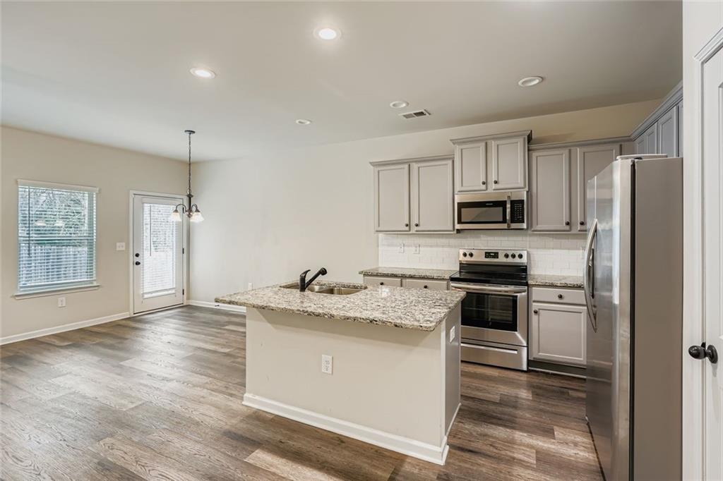 1901 Creel Lane Atlanta, GA 30349 - Photo 15 of 28 a kitchen with stainless steel appliances granite countertop a sink stove refrigerator and cabinets