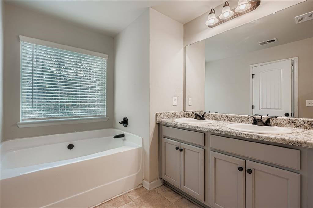 1901 Creel Lane Atlanta, GA 30349 - Photo 20 of 28 a bathroom with a tub sink and mirror