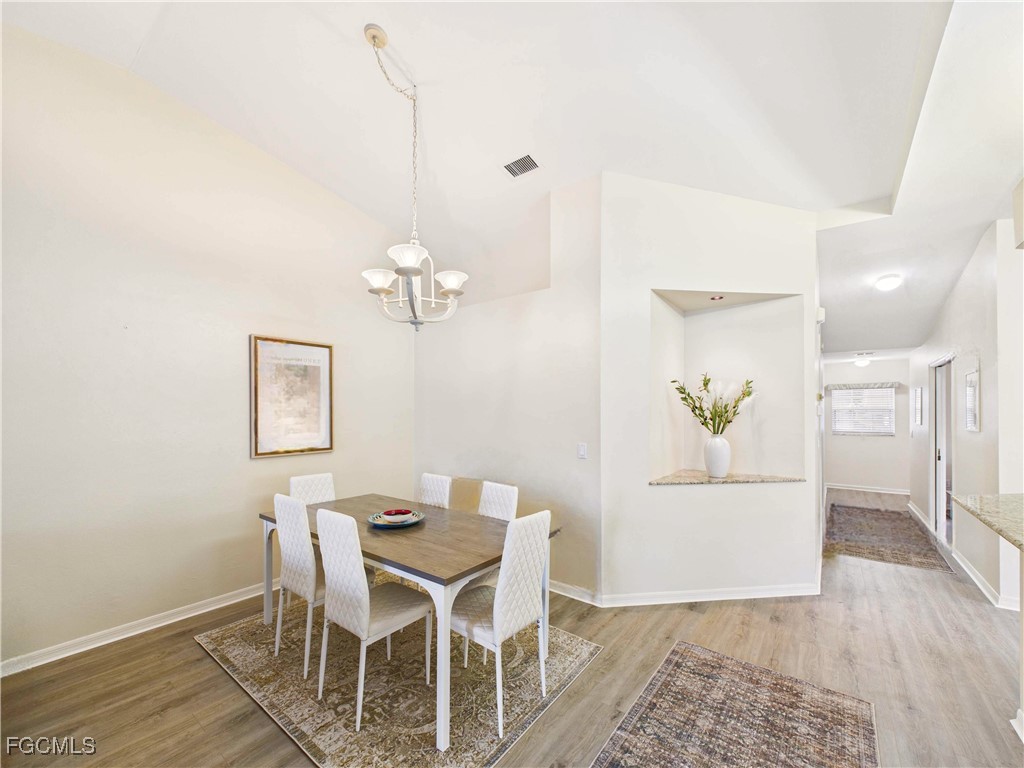 7435 Plumbago Bridge Road, Unit K201 Naples, FL 34109 - Photo 15 of 35 a view of a dining room with furniture and wooden floor