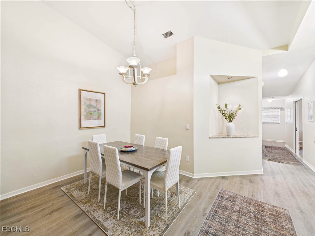 7435 Plumbago Bridge Road, Unit K201 Naples, FL 34109 - Photo 16 of 35 a view of a dining room with furniture and wooden floor